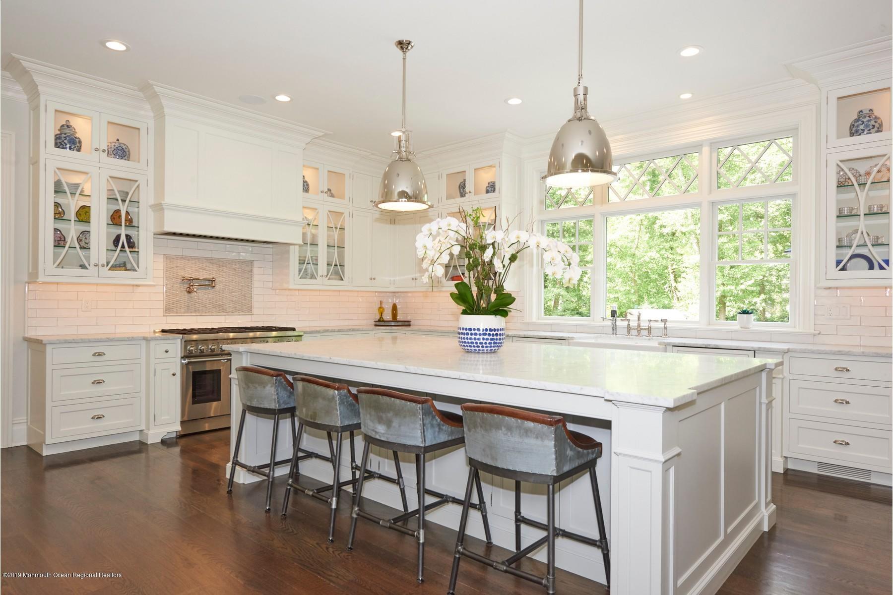 8 Heathcliff Road Rumson, NJ 07760 - Photo 5 of 46 a kitchen with a stove a table and chairs in it