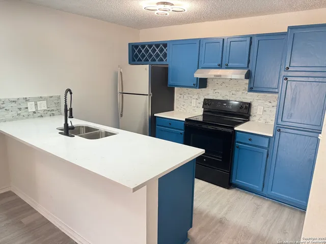a kitchen with a refrigerator and a sink