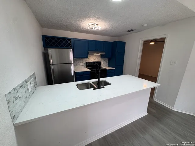 a kitchen with a sink and a refrigerator