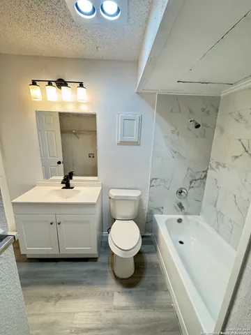 a view of a room with a ceiling fan and wooden floor