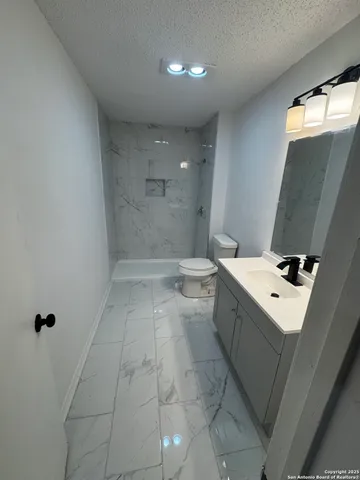 an empty room with wooden floor fan and window