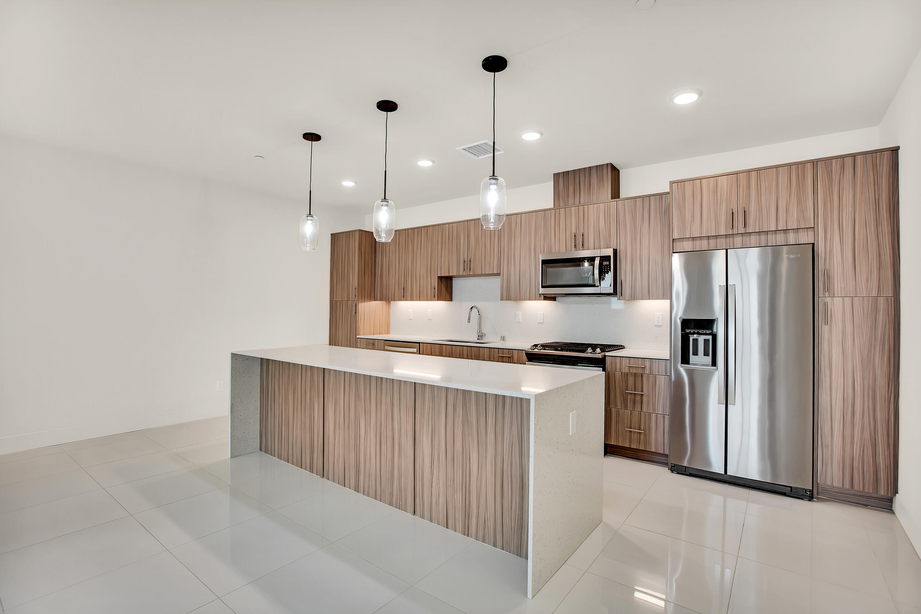 191 The Riv Palm Springs, CA 92262 - Photo 13 of 33 a kitchen with stainless steel appliances granite countertop a refrigerator a stove a sink and a microwave