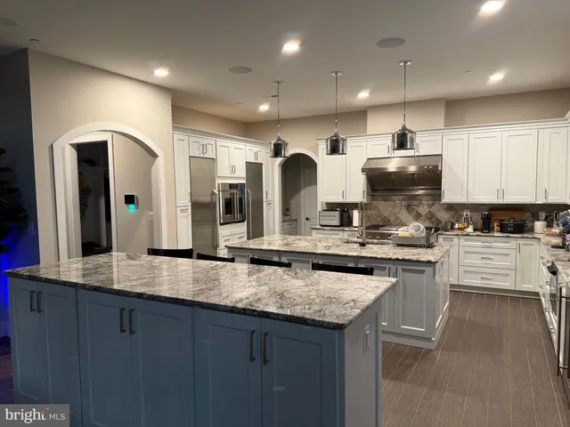 a large kitchen with stainless steel appliances granite countertop a stove and a sink