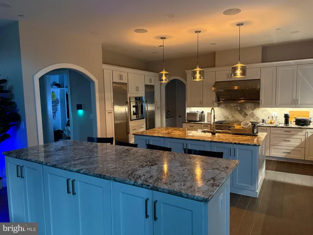 a kitchen with granite countertop a sink a counter space and stainless steel appliances
