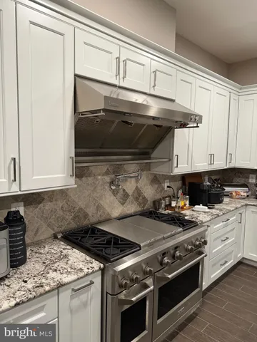 a kitchen with granite countertop a stove and a microwave