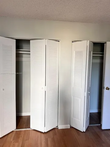 a view of closet area with hardwood floor