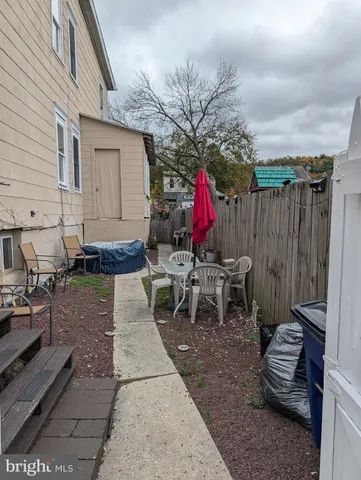 a view of a house with backyard sitting area and garden