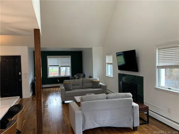 a living room with furniture a flat screen tv and a fireplace