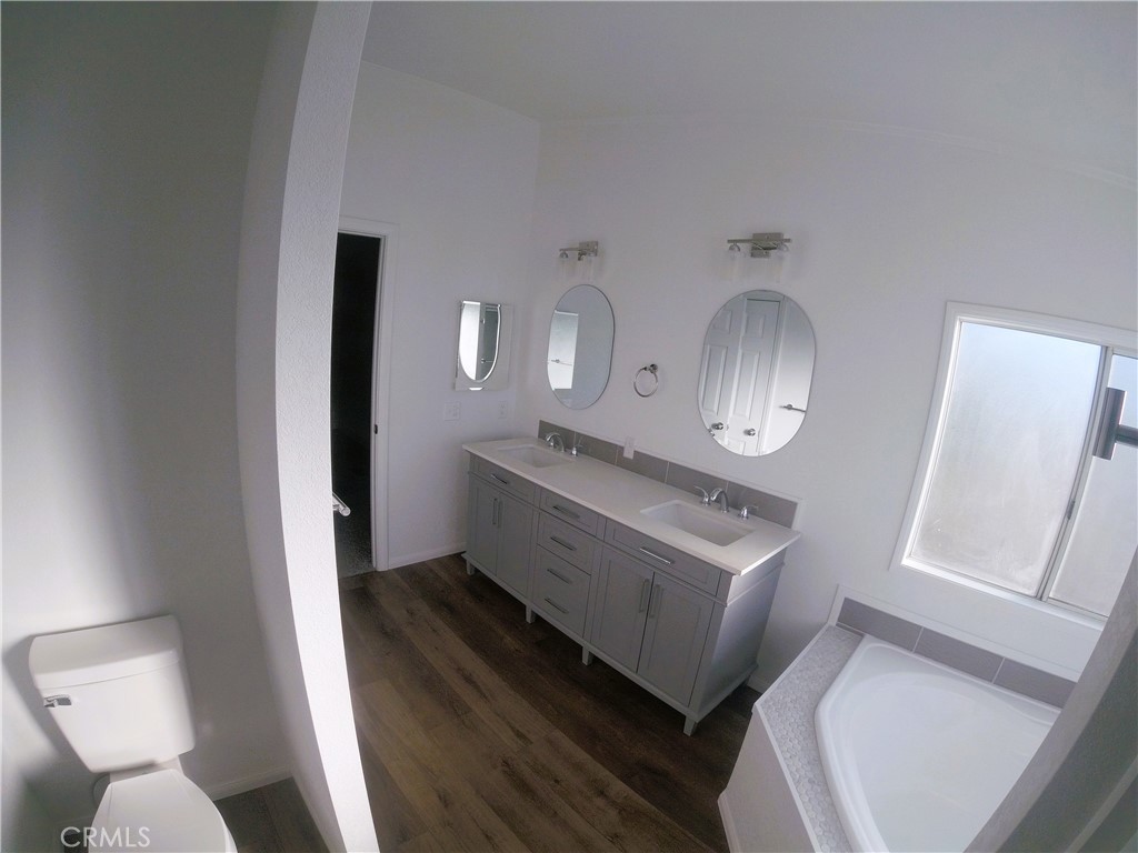 14058 Monte Vista Road Phelan, CA 92371 - Photo 15 of 17 a bathroom with a toilet sink and mirror