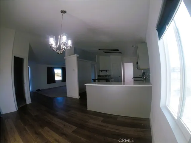 a dining room with wooden floor a chandelier a wooden table and chairs