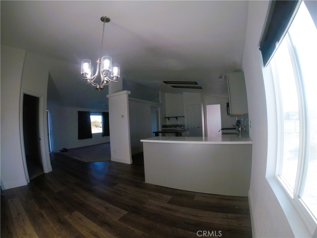 14058 Monte Vista Road Phelan, CA 92371 - Photo 5 of 17 a dining room with wooden floor a chandelier a wooden table and chairs