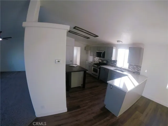 a kitchen with granite countertop a refrigerator and a stove top oven