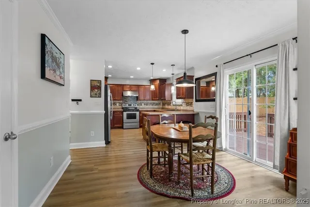 a dining room with furniture a chandelier and wooden floor