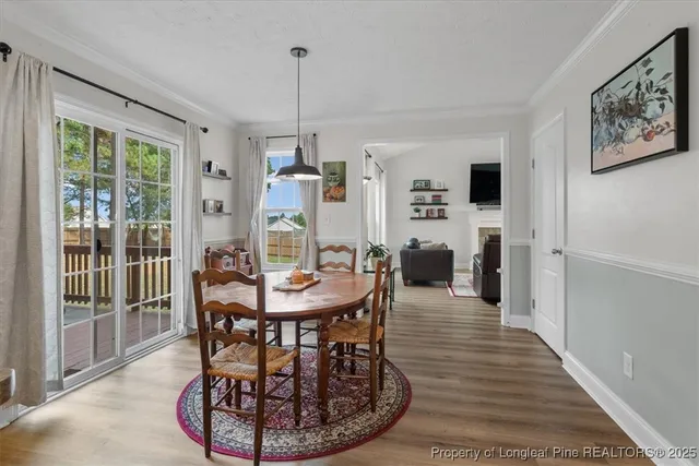 a dining room with furniture a chandelier and wooden floor