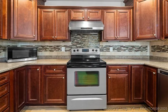 a kitchen with stainless steel appliances granite countertop a stove top oven microwave and cabinets