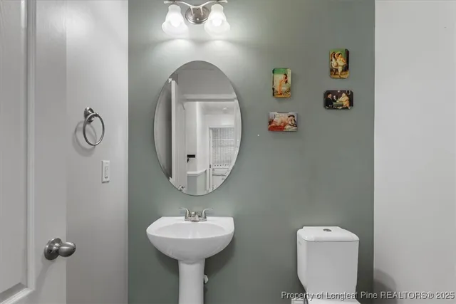 a bathroom with a toilet sink and mirror