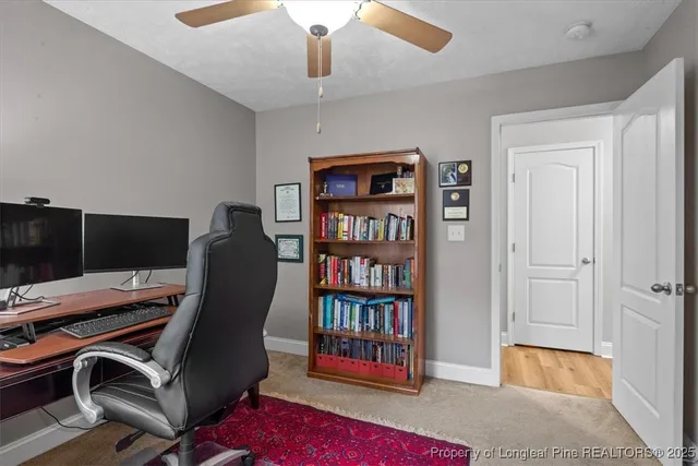 a view of a workspace with furniture and bookshelf
