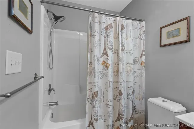 a bathroom with a shower curtain and a toilet