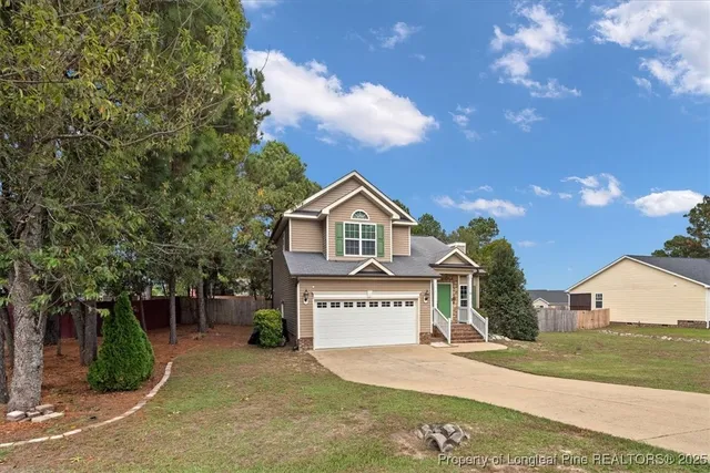 a view of a house with a yard and tree s