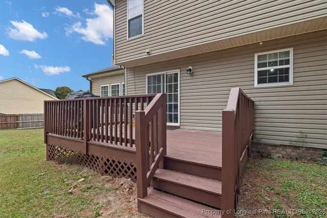 a view of backyard with deck and outdoor seating