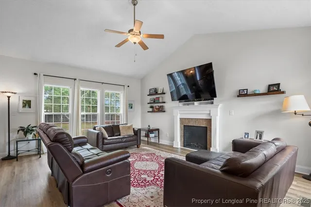 a living room with furniture a fireplace and a flat screen tv
