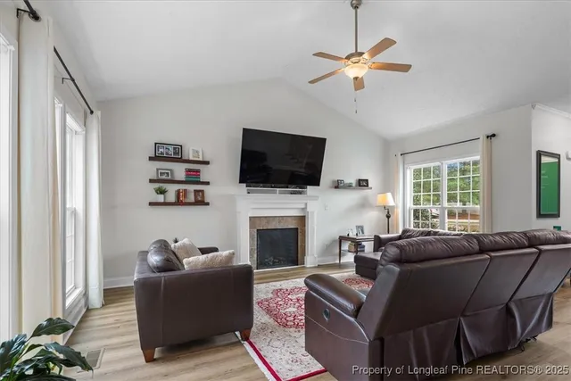 a living room with furniture a fireplace and a flat screen tv