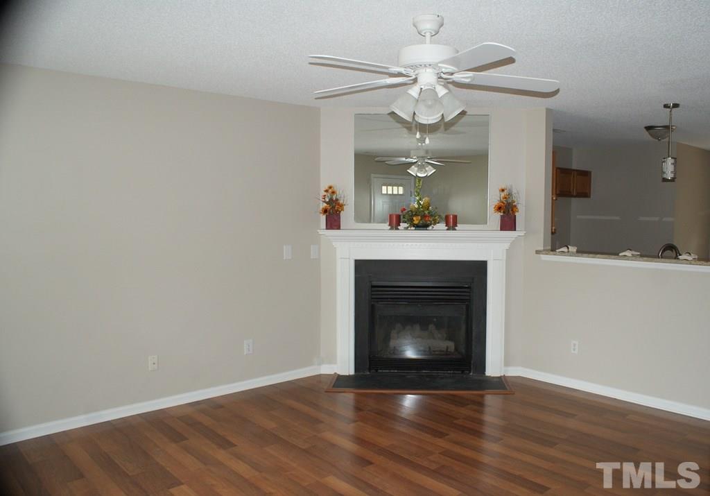 2001 Pineton Court Raleigh, NC 27610 - Photo 3 of 16 Living Room/Family room with wood like laminate floors. Neutral walls and ceiling fan enhances this grand room. Relax in front of the fireplace when the temperature goes down.