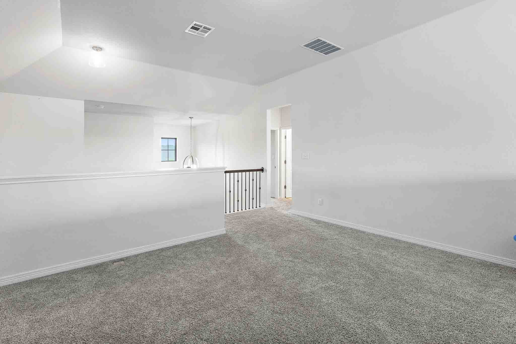 166 West Branch Road Kyle, TX 78640 - Photo 24 of 39 An inviting open loft space with plush carpeting, perfect for relaxation or a home office.