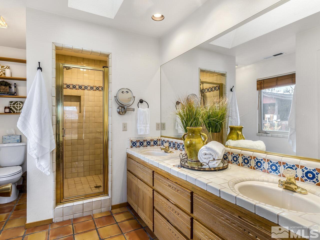 1010 Foothill Road Reno, NV 89511 - Photo 20 of 40 a bathroom with a granite countertop sink a mirror and shower