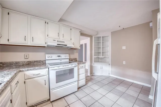 a kitchen with white cabinets and white appliances