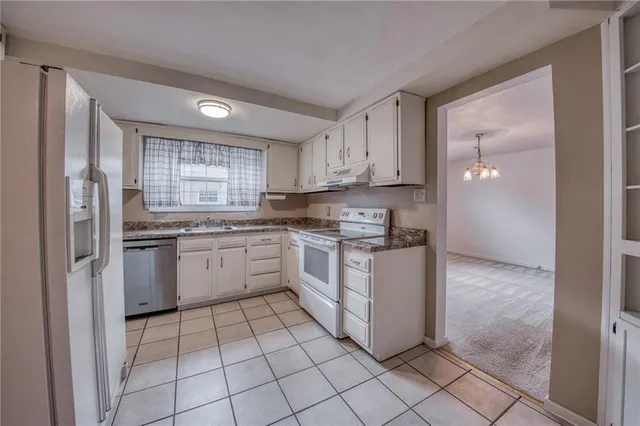 a kitchen with white cabinets and white appliances