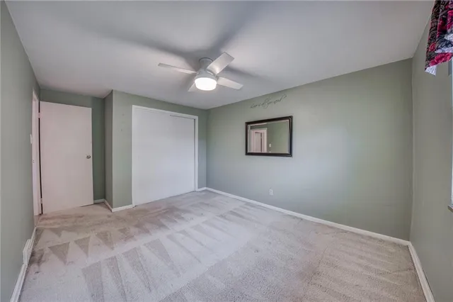 a view of an empty room with a ceiling fan