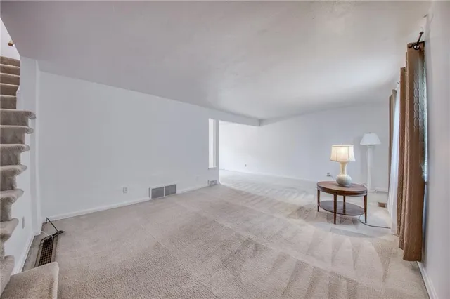 an empty room with furniture and a lamp