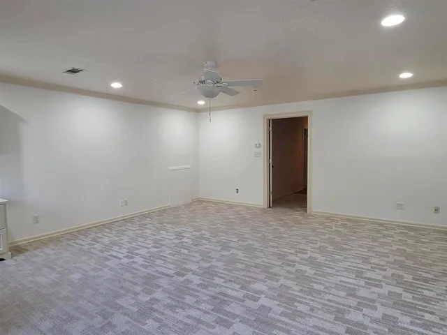 an empty room with windows and cabinet