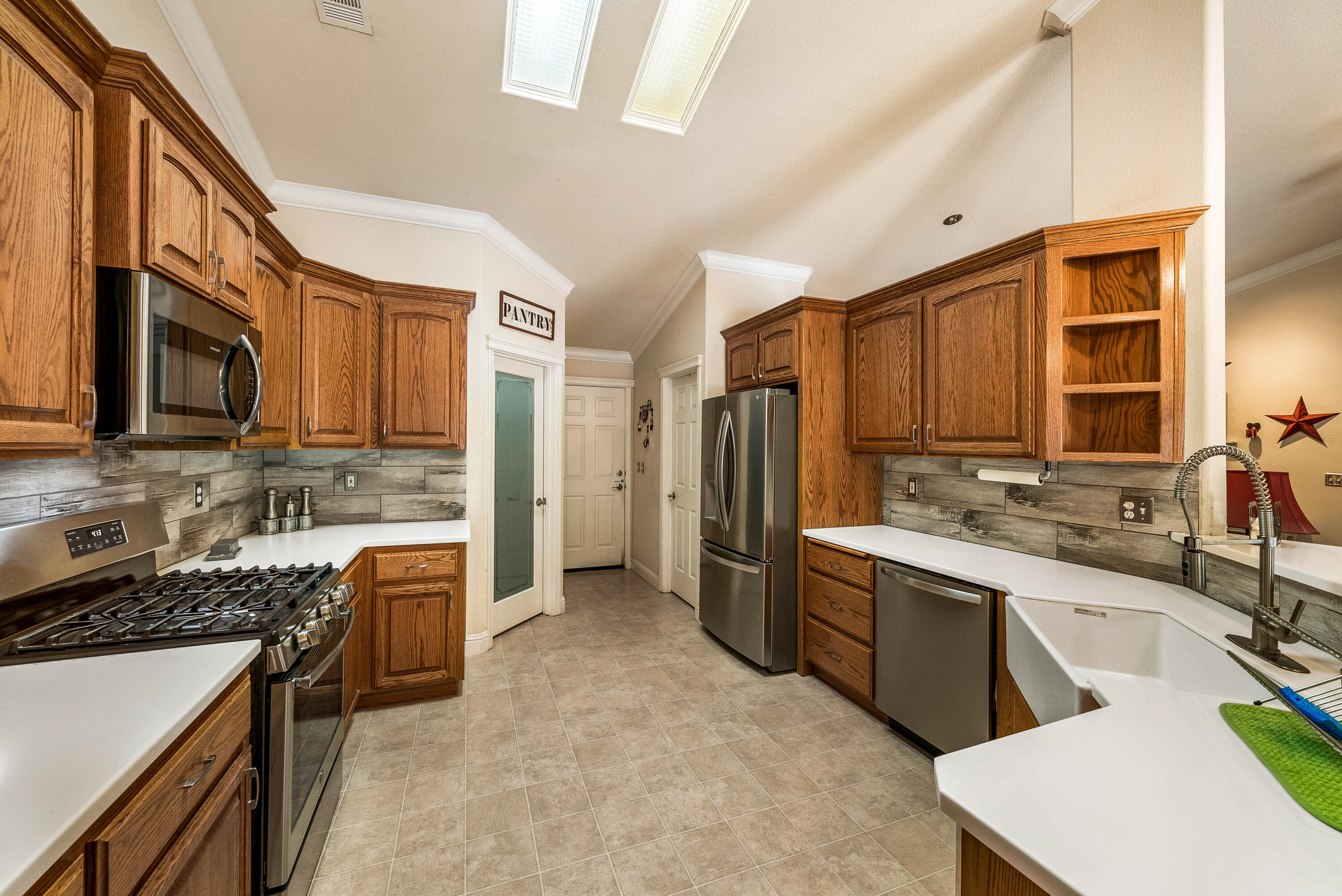 3255 Lawrence Road Redding, CA 96002 - Photo 12 of 27 a kitchen with stainless steel appliances granite countertop a stove top oven a sink dishwasher a refrigerator and cabinets with wooden floor