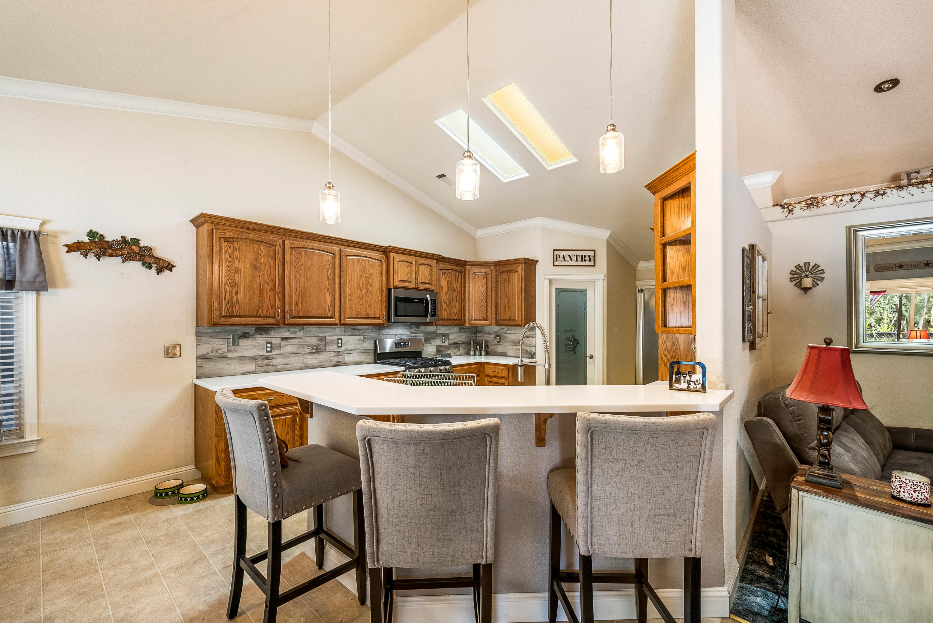 3255 Lawrence Road Redding, CA 96002 - Photo 13 of 27 a kitchen with stainless steel appliances kitchen island granite countertop a sink a stove and chairs