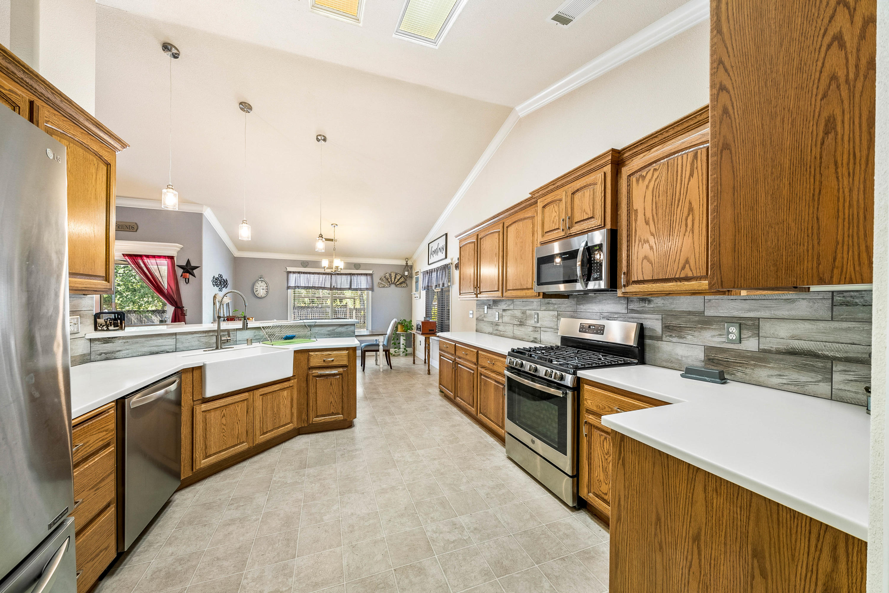 3255 Lawrence Road Redding, CA 96002 - Photo 10 of 27 a large kitchen with stainless steel appliances granite countertop a stove top oven a sink dishwasher a dining table and chairs with wooden floor