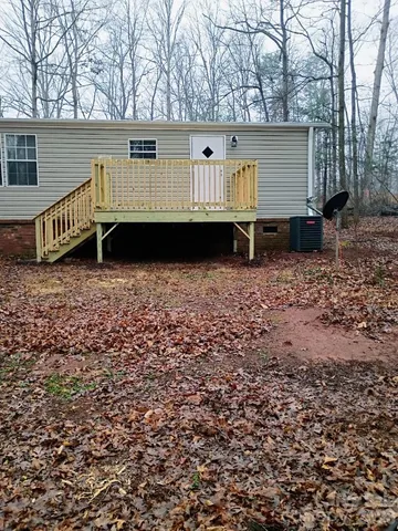 a view of a house with backyard and trees