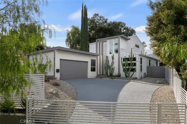 a view of a house with backyard and trees