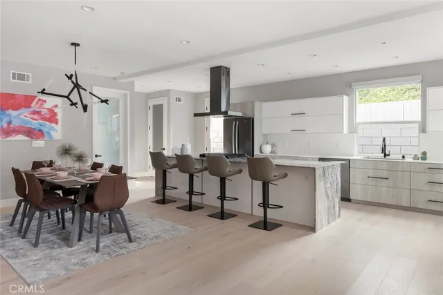 a kitchen with granite countertop a sink cabinets and dining table