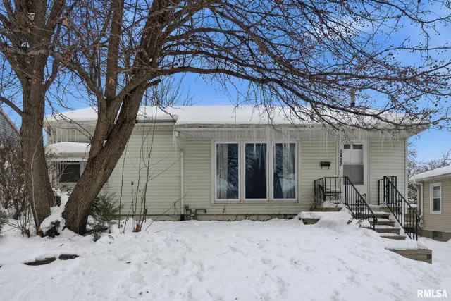 a backyard of a house with large tree and wooden fence