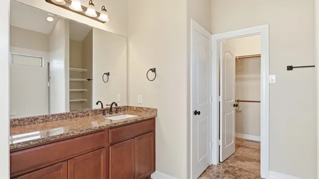 a bathroom with a granite countertop sink and a mirror