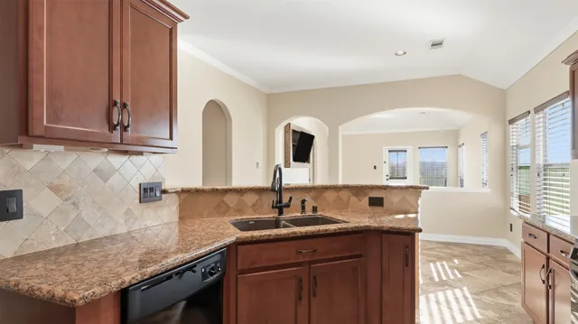a kitchen with granite countertop a sink and a wooden cabinets