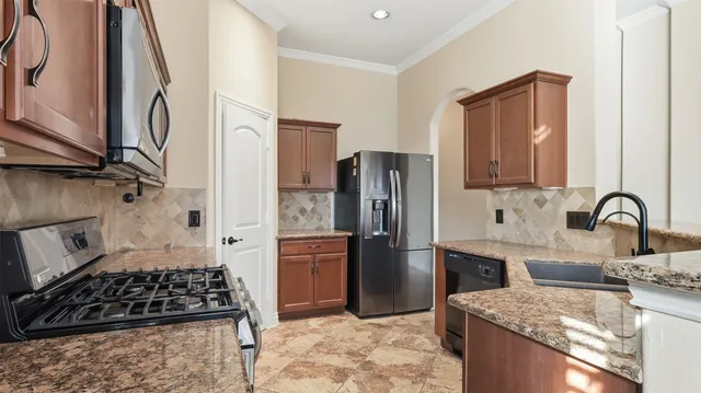 a kitchen with stainless steel appliances granite countertop a refrigerator and a stove