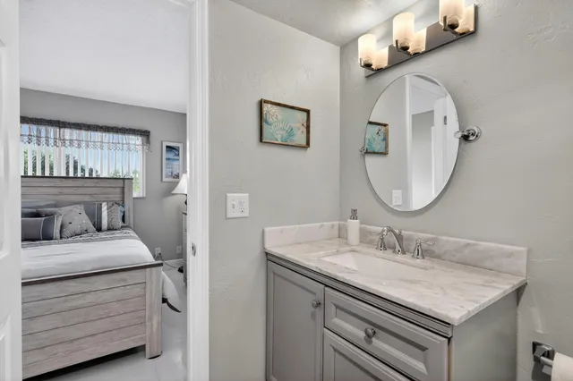 a bathroom with a granite countertop sink a toilet and a mirror