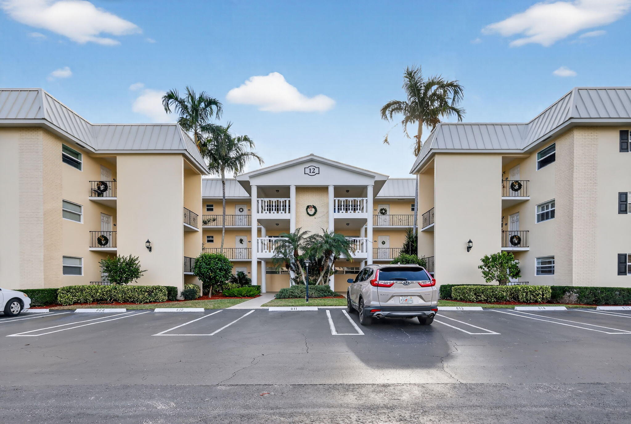 12 Colonial Club Drive, Unit 305 Boynton Beach, FL 33435 - Photo 2 of 51 a car parked in front of a white house
