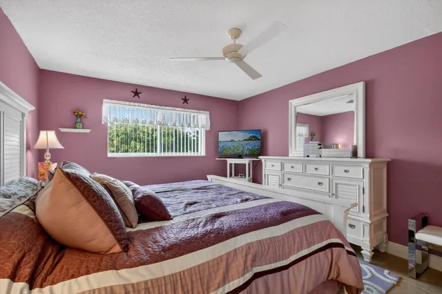 a bedroom with a bed a chandelier and dresser