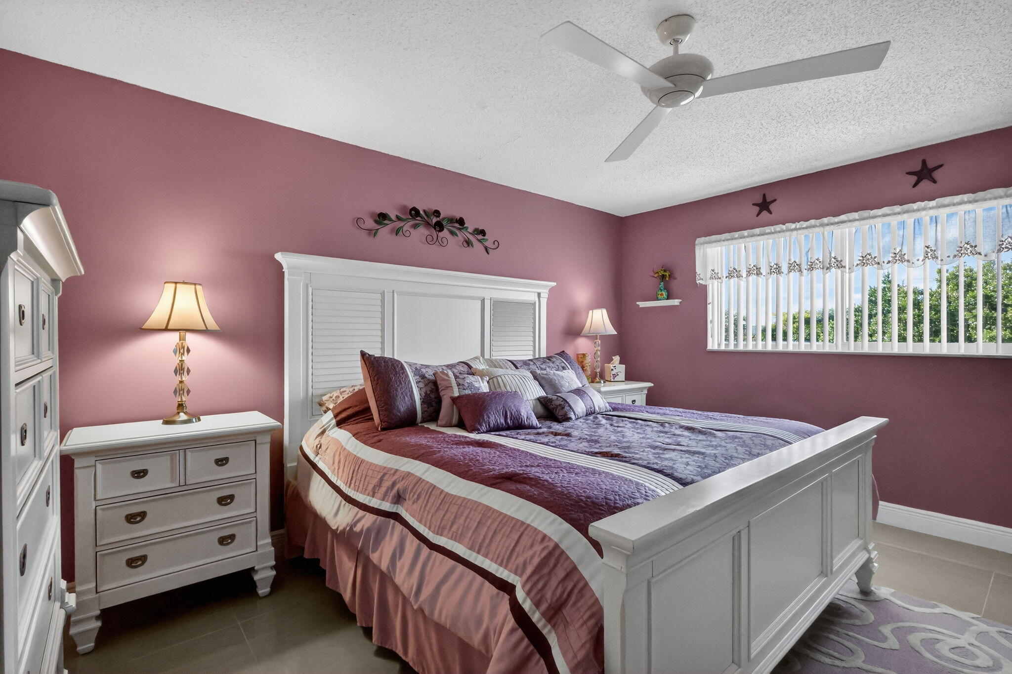 12 Colonial Club Drive, Unit 305 Boynton Beach, FL 33435 - Photo 22 of 51 a bedroom with a bed a chandelier and dresser