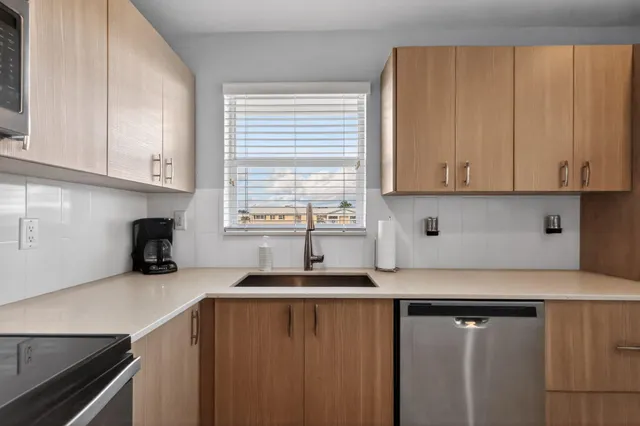 a kitchen with granite countertop a sink cabinets and window
