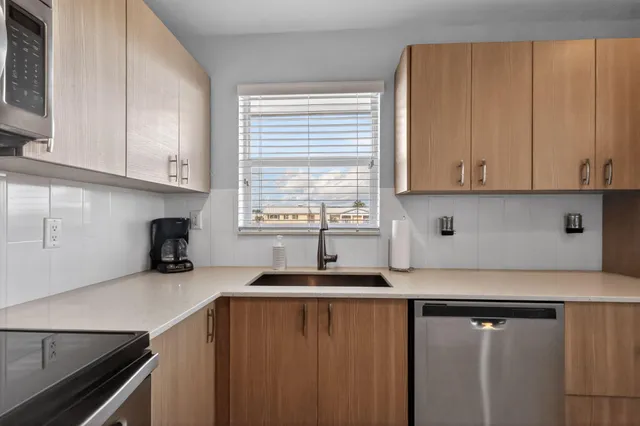 a kitchen with stainless steel appliances granite countertop a refrigerator and a sink